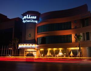 un bâtiment avec un panneau en haut de celui-ci la nuit dans l'établissement Sanam Hotel Suites - Riyadh, à Riyad