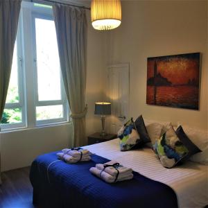 1 dormitorio con 2 toallas en una cama con ventana en Trefoil Apartment - 2 Bedrooms, en Glasgow