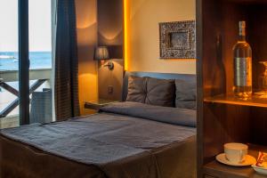 a bedroom with a bed and a bottle of wine at Hotel Capo San Vito by Geocharme in San Vito lo Capo