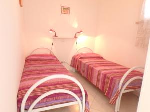 twee bedden in een kamer met twee stoelen bij Appartamenti Vittoria in Lido di Pomposa