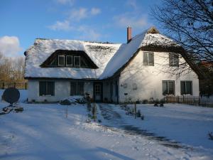 a white house with snow on the roof at Haus Bernsteinchen in Gustow