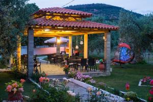 a gazebo with tables and chairs in a garden at Pension Maria in Astris