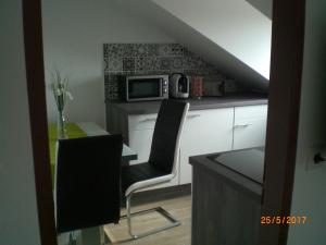 eine kleine Küche mit einem Schreibtisch und einer Mikrowelle in der Unterkunft Ferienwohnungen Feldsee in Illmitz