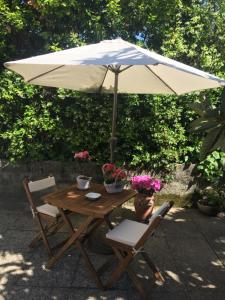 a wooden table with an umbrella and two chairs at B&B La Casa di Elsa in Marina di Massa