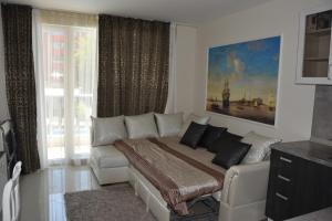a bedroom with a bed and a couch and a window at Admiral Plaza Apartments in Sunny Beach