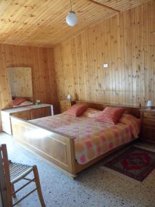 una camera con un grande letto in una stanza con pareti in legno di La Borgata a Boiano
