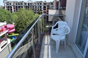 a balcony with a white chair on a balcony at Admiral Plaza Apartments in Sunny Beach