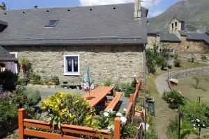 una casa de piedra con un banco delante en Gîte Soum de l'Ase en Grust