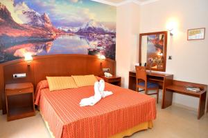 a bedroom with a bed with a white animal on it at Hotel Portonovo in Portonovo