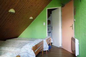1 dormitorio con 1 cama en una pared verde en Gîte Soum de l'Ase en Grust