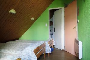 a bedroom with a bed in a green wall at Gîte Soum de l'Ase in Grust