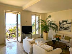 sala de estar con muebles blancos y TV en Citilet Louis Blanc 1,2,3 - Three gorgeous, open-plan apartments, en Cannes