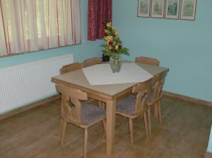 a table and chairs with a vase of flowers on it at Haus Renarth - Michaela Pro in Kitzeck im Sausal