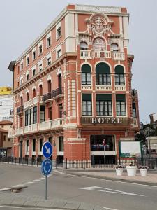 a large red building with a hotel on a street at Marina in Ribadesella