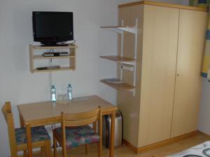 a room with a table and a tv and a small table and chair at Haus Renarth - Michaela Pro in Kitzeck im Sausal