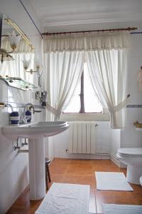 a bathroom with a sink and a toilet and a window at Casa De Cacheiro in Silleda