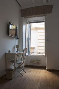 biurko i krzesło w pokoju z oknem w obiekcie Splendid House In Trastevere w Rzymie