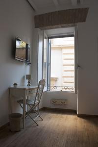 ローマにあるSplendid House In Trastevereの窓付きの客室で、デスクと椅子が備わります。