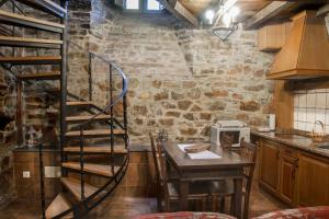a kitchen with a spiral staircase in a brick wall at Apartamentos Vilarchao in Vilarchao