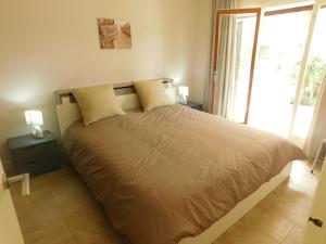 ロザスにあるGMID IMMO Apartamento Punta Pelegríのベッドルーム1室(大型ベッド1台、ランプ2つ付)