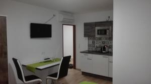 eine kleine Küche mit einem Tisch und Stühlen in einem Zimmer in der Unterkunft Ferienwohnungen Feldsee in Illmitz