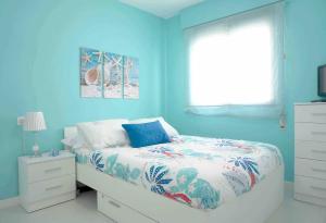 una camera da letto blu con un letto e una finestra di Apartment Covelo a Samieira