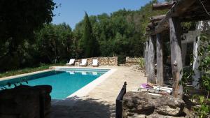 una piscina con sillas junto a una casa en Cortijo del Sueño, en Vejer de la Frontera