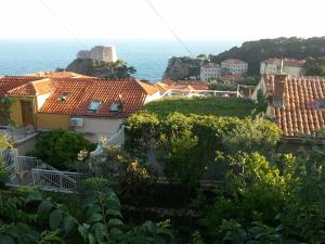 a view of roofs of houses and the ocean at Room & Apartment Saint John in Dubrovnik
