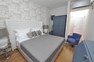 ein Schlafzimmer mit einem großen Bett und einem blauen Stuhl in der Unterkunft Bajamonti 5 Luxury Rooms in Split