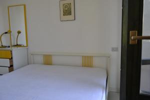 a bedroom with a white bed and a picture on the wall at Roberta Apartment in Marcelli