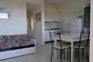 a living room with a table and chairs and a couch at Roberta Apartment in Marcelli +8 photos