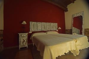 a bedroom with two beds and a red wall at Molinos de Antero in Monforte de Lemos