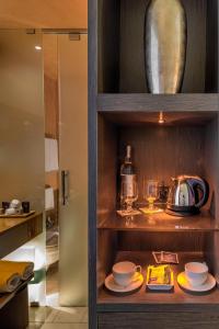 a cabinet with dishes and a tea pot on it at Hotel Capo San Vito by Geocharme in San Vito lo Capo