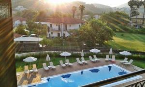 a view of a swimming pool with chairs and umbrellas at Villa Dimitris in Parga