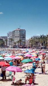 duża grupa ludzi na plaży z parasolami w obiekcie Apartment Manuel Galián 52 w mieście Torrevieja