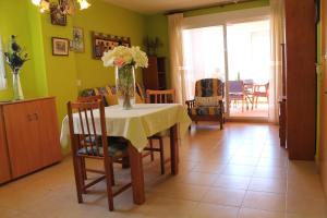 a dining room with a table with a vase of flowers on it at Mar Azul in Peniscola