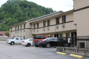 a building with cars parked in a parking lot at American Elite Inn in Hazard +37 photos