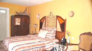 a bedroom with a bed and a dresser in it at Casa De Piedra, Centro Histórico in Mérida