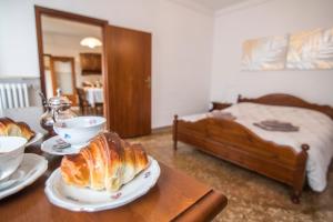Ca' Dada Appartamento في البندقية: طاولة مع طبقين من الخبز وسرير