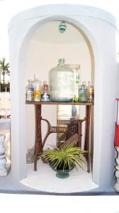 a shelf with a pot on a table with a plant at Casa De Piedra, Centro Histórico in Mérida