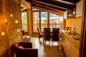a kitchen and dining room with a table and chairs at Chalet Alpina Hotel & Apartments in La Thuile