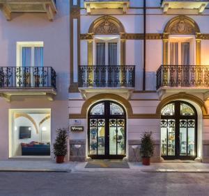 a tall building with windows and balconies on it at Viacolvento in Marsala