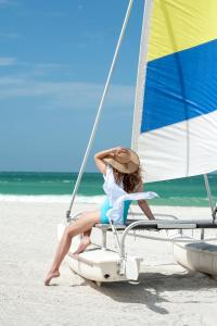 a woman sitting on a boat on the beach at Sandcastle Resort at Lido Beach in Sarasota