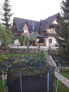 a house with a golf course in front of it at Mala Chatka in Wetlina