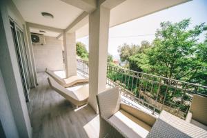 a balcony with chairs and a large window at Apartments Horizont in Budva