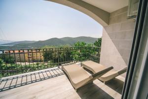 a balcony with a table and chairs and mountains in the background at Apartments Horizont in Budva