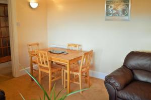 Zimmer mit einem Tisch, Stühlen und einem Sofa in der Unterkunft Hazel Bank Villa Apartment in Dunoon