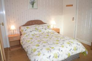 ein Bett in einem Schlafzimmer mit zwei Nachttischen und zwei Lampen in der Unterkunft Hazel Bank Villa Apartment in Dunoon