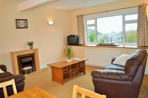 a living room with a couch and a fireplace at Hazel Bank Villa Apartment in Dunoon