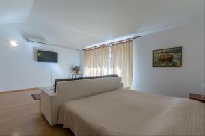 a white bedroom with a bed and a window at Apartment Zdravka in Crikvenica